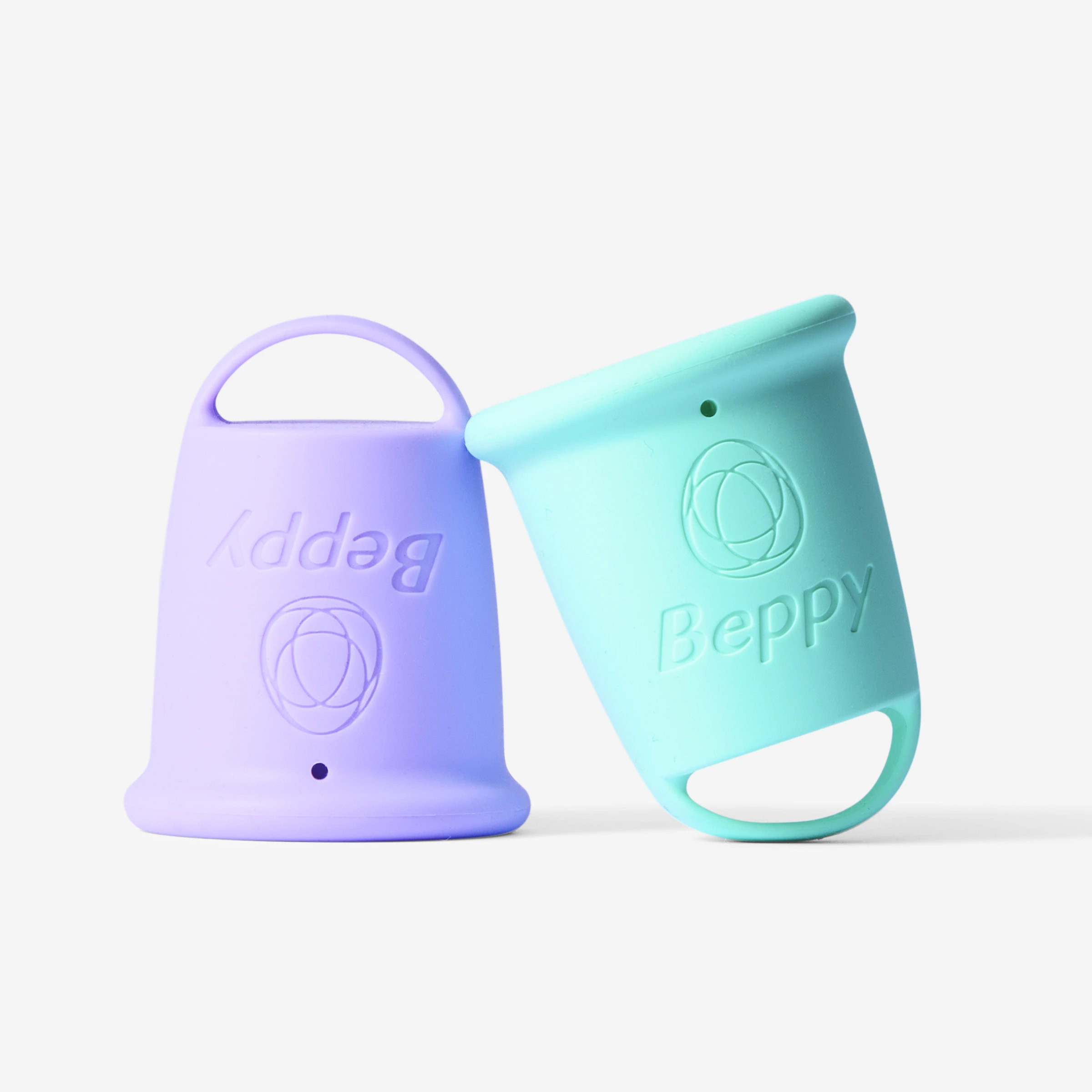 Two Beppy reusable menstrual cups in pastel purple and teal colours, shown upright and angled, with loop handles and embossed Beppy branding on a white background.