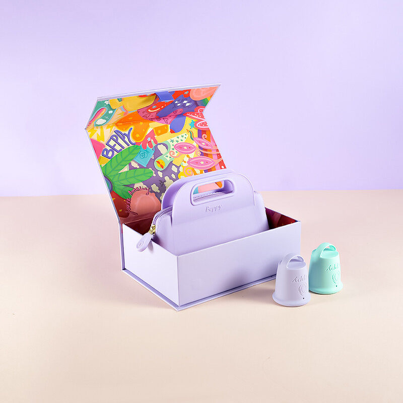 Beppy Menstrual Cup Wonder Set displayed in an open box, showing a lavender storage pouch and two reusable menstrual cups in pastel purple and mint green on a studio background.