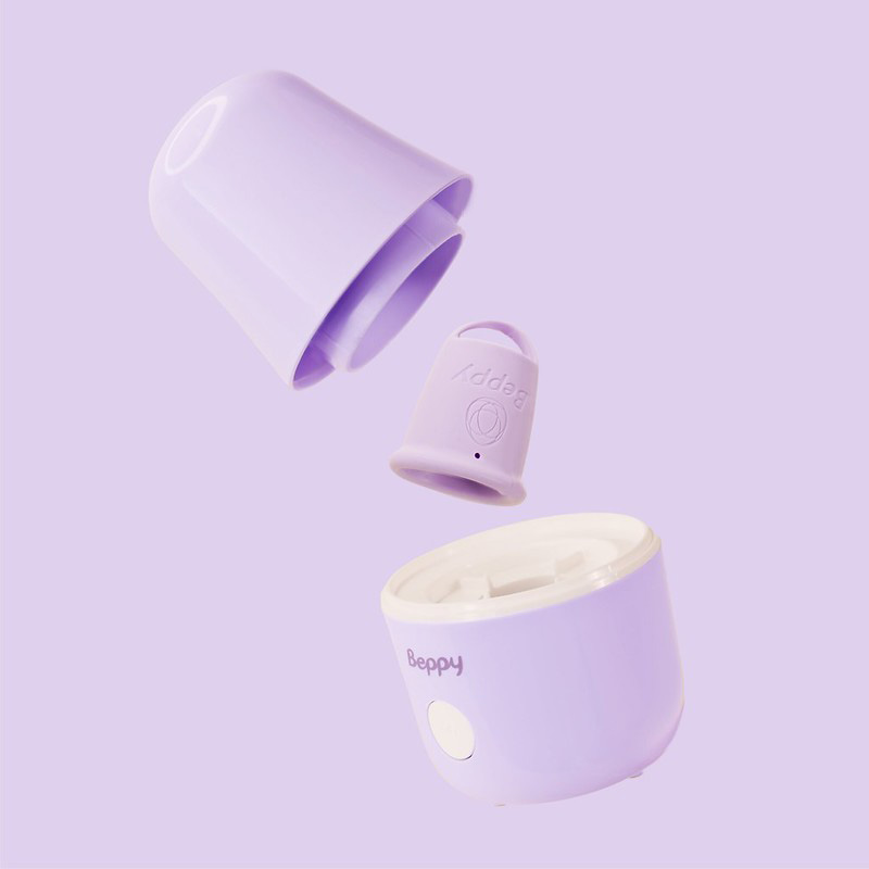 Exploded view of the Beppy menstrual cup steam sterilizer showing lid, internal cup holder, and base unit, compact lavender device designed to disinfect menstrual cups using steam and water for safe, hygienic period care.