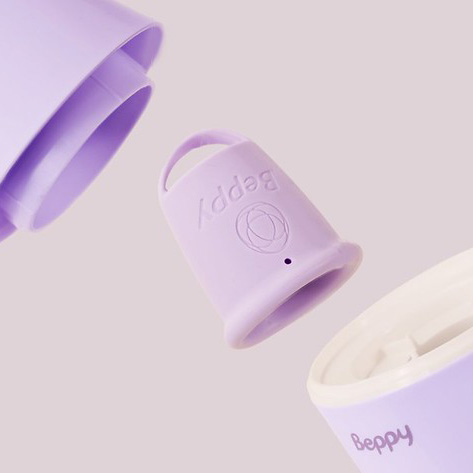 Close-up exploded view of the Beppy menstrual cup sterilizer showing the removable internal cup holder between the lid and base, highlighting the compact steam sterilisation design for hygienic menstrual cup cleaning.
