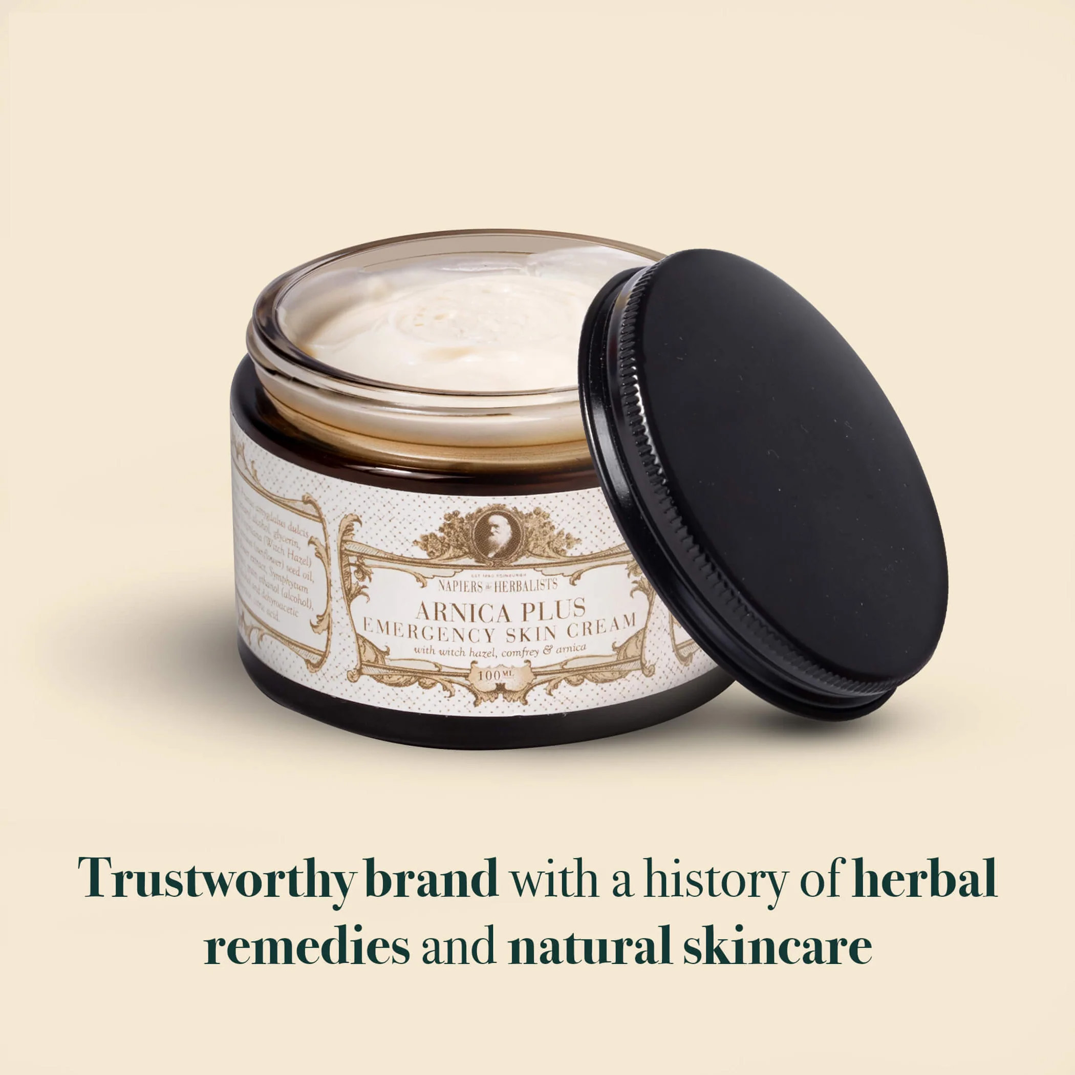 Open jar of Napiers Arnica Plus Emergency Skin Cream showing the creamy texture inside, a herbal skin cream made with arnica, witch hazel and comfrey, from a trusted brand known for traditional herbal remedies and natural skincare.