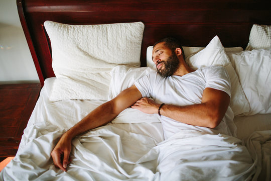Man lying in bed looking tired or concerned, representing the emotional or physical fatigue that can be associated with erectile dysfunction and discussions about assessing personal risk. Erectile Dysfunction: How High Is Your Risk?-StressNoMore