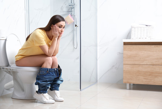 Person sitting on the toilet appearing strained and uncomfortable, representing constipation, digestive issues, suitable for bowel health and pelvic floor awareness. Use a toilet stool. Stressnomore.