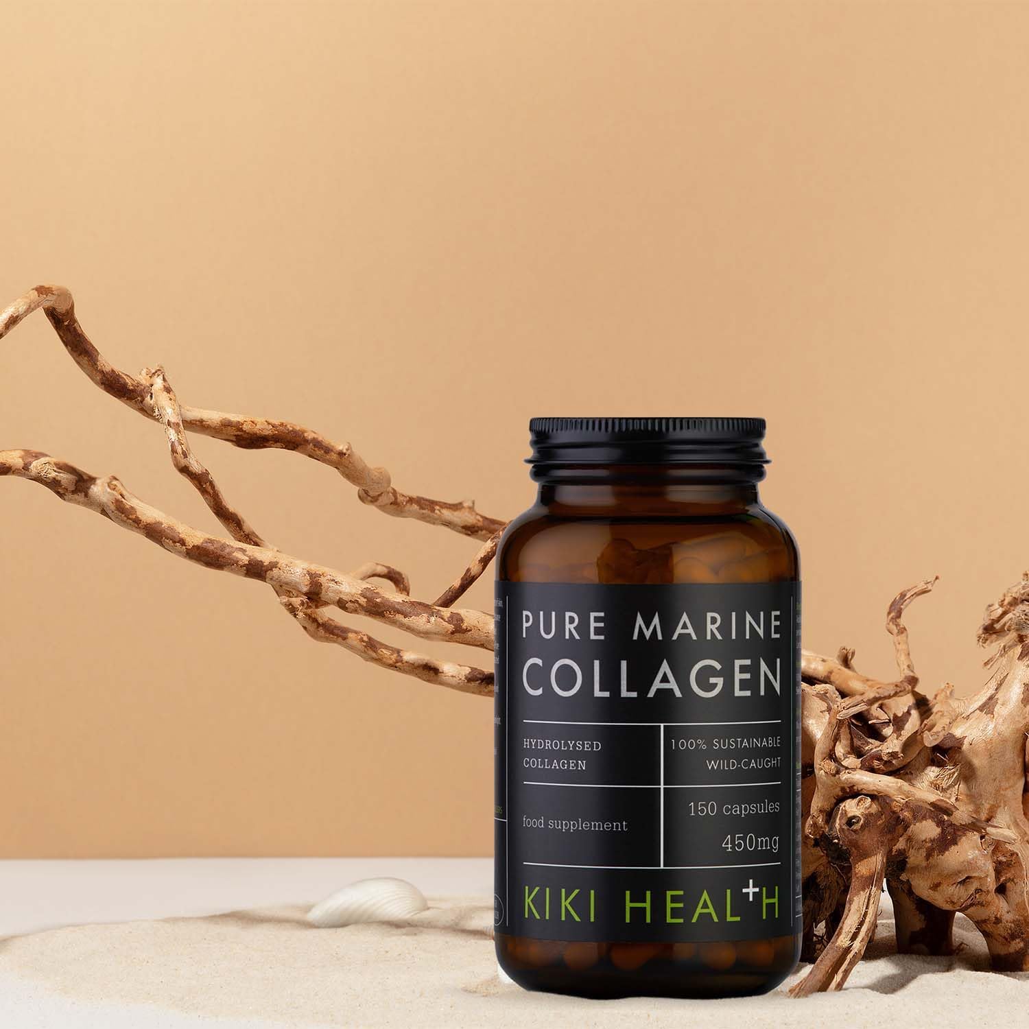 KIKI Health Pure Marine Collagen Capsules in a dark glass jar displayed on sand with natural driftwood elements against a warm neutral background.