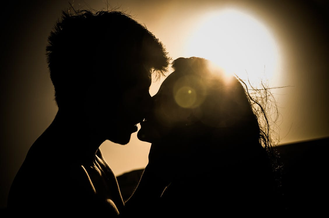 Can a Strong Pelvic Floor Be the Key to an Amazing Sex Life?-StressNoMore. Silhouette of a couple sharing an intimate kiss at sunset, representing connection, desire and how pelvic floor strength can enhance sexual wellbeing.