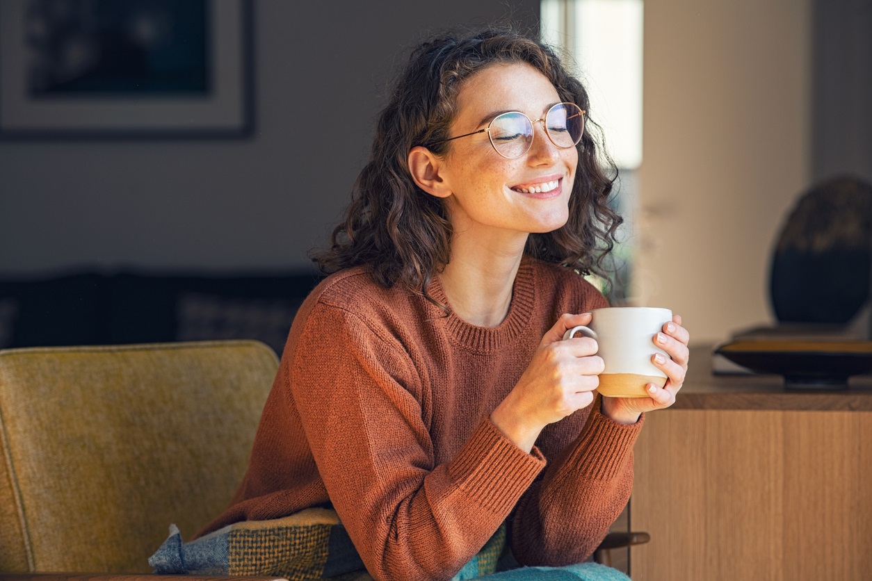 Woman enjoying a peaceful moment with a cup of tea or coffee, illustrating the importance of self-care, mindfulness, and taking time to unwind. The Importance of Self Care-StressNoMore