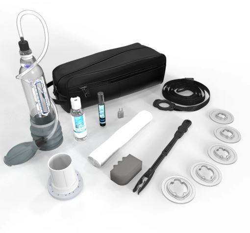 VaxAid v7 Deluxe penis pump kit laid out showing hydro vacuum erection device, handball pump, erection support rings, lubricant, comfort pad, towel, tubing, instruction tools, and carry case for erectile dysfunction therapy.