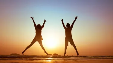 Two people jumping with arms raised on a beach at sunset, creating joyful silhouettes against the colourful sky. Why Vaginal Weights Like KegelFlex Really Work – Strengthen Your Pelvic Floor in Just Minutes a Day.