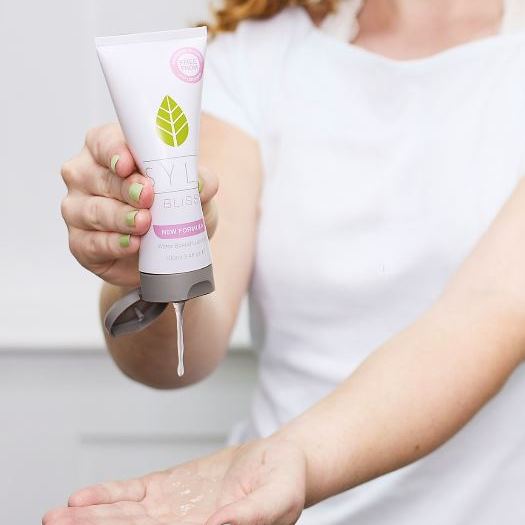 Person dispensing SYLK BLISS natural water-based lubricant from tube into hand, demonstrating application of plant-based, gentle intimate lubricant designed to support comfort, hydration, and everyday intimate care.