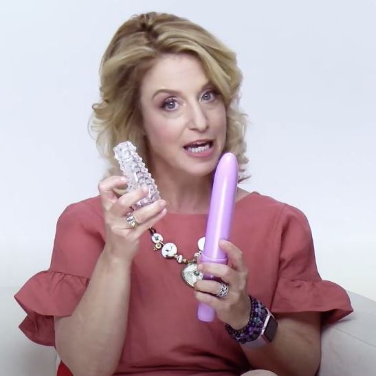 Woman demonstrating vaginal dilator therapy tools, holding a pink vaginal dilator and a removable textured silicone sleeve, used for pelvic floor rehabilitation, vaginismus support, and vaginal dilation therapy.
