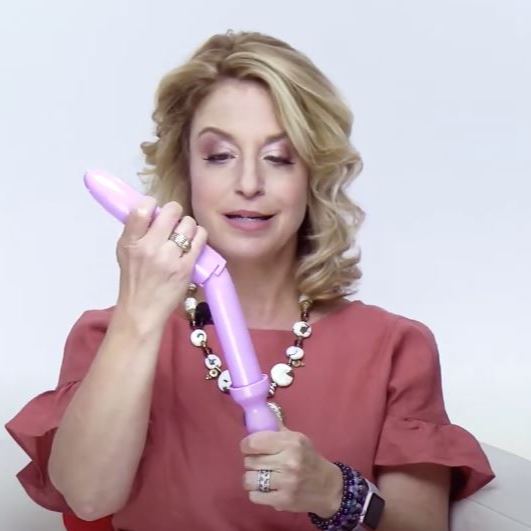 Dr. Laura Berman demonstrating a pink vaginal dilator with vibrating handle, showing how to use the pelvic floor therapy device for vaginismus and vaginal dilation treatment.