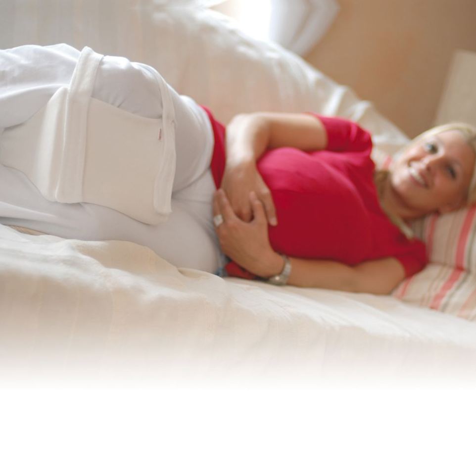 Woman side sleeping with SISSEL Medi Position Support knee and hip cushion, ergonomic leg separator for spinal alignment, joint pain relief and post-surgery recovery.