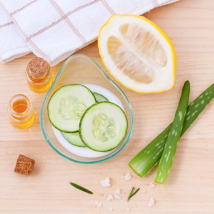 Natural skincare ingredients such as aloe vera, cucumber, lemon and essential oils arranged on a table, used to compare natural vs chemical skincare products. Natural Vs Chemical Skincare Products-StressNoMore