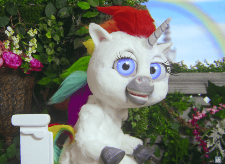 Squatting Gone Viral! This Unicorn Could Change The Way You Poo!-StressNoMore. Colourful cartoon unicorn with bright eyes and a rainbow mane sitting outdoors, featured in a viral video promoting healthier toilet posture through squatting.