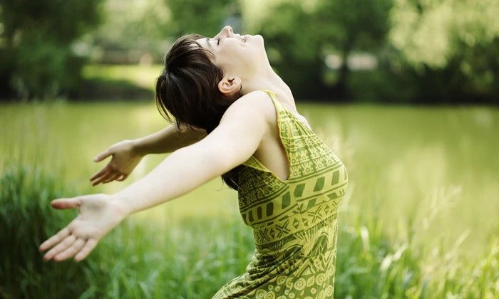 Enjoy Effective, Natural and Fast Pain Relief in Minutes-StressNoMore. Woman outdoors with arms open and head back, expressing freedom, joy and deep relaxation, ideal for wellbeing, mental health, mindfulness, stress relief and outdoor wellness.