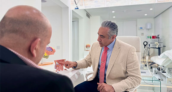 Almashan 先生在与客户进行咨询时指着骨盆模型