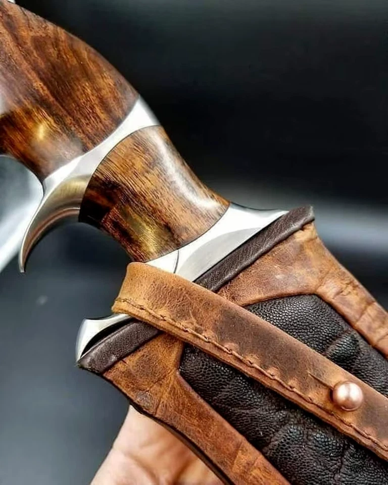 Ręcznie wykonany nóż myśliwski typu Bowie ze stali damasceńskiej o ponad 216 warstwach, w komplecie ze skórzaną pochwą.