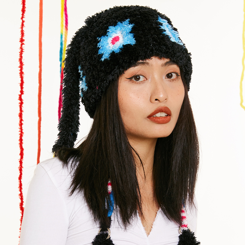 Front view of a model wearing the black Bunny Ear Crochet Hat, featuring fluffy yarn texture and long dangling animal ears.