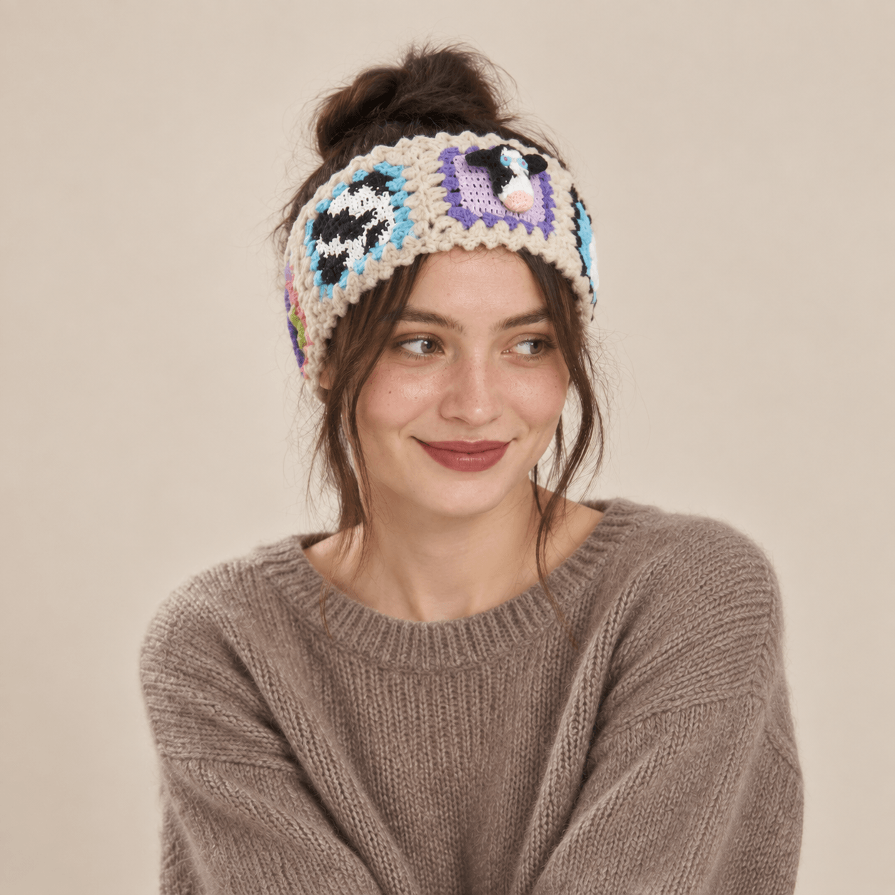 FeekyStore crochet cow headband featuring playful animal motifs and colorful granny square patchwork, worn by a model in a clean studio setting.