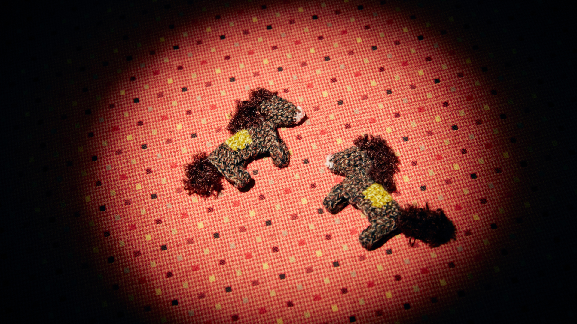 Two cute dark brown crochet horse keychains displayed under a spotlight against a dopamine-style dotted background with vibrant red  and yellow  tones.