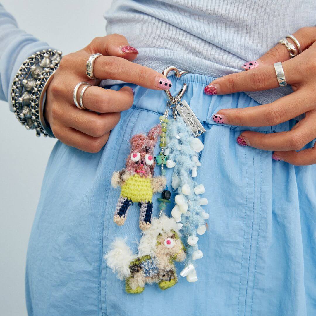 A creative styling shot showing the Bunny & Pony charm hooked onto a denim belt loop, highlighting its versatility as a fashion accessory.