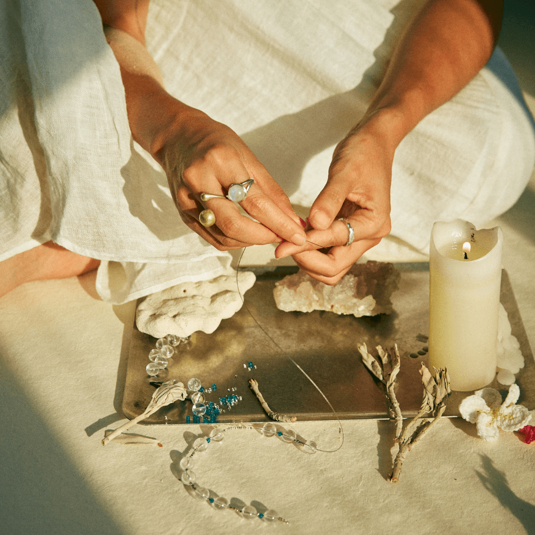 {"default":"hands making handmade beaded jewelry in soft light"}
