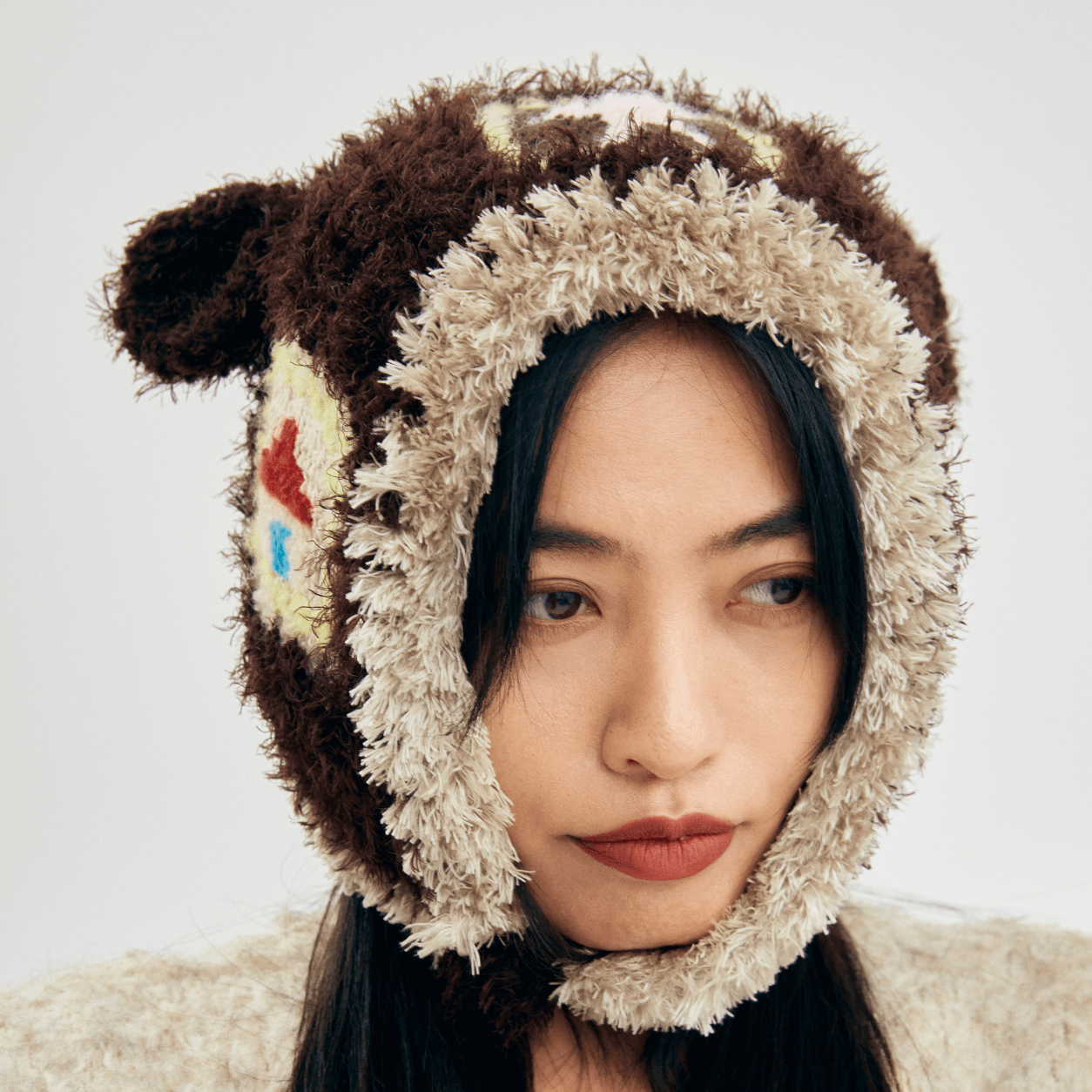 Front close-up of the Little Lamb Patchwork Hat showing the soft cream crochet trim framing the face.
