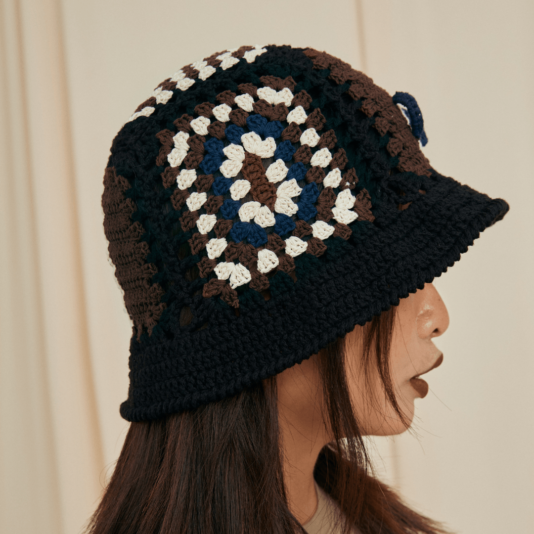 FeekyStore black crochet bucket hat featuring a side profile view of the signature vase motif and textured stitching.