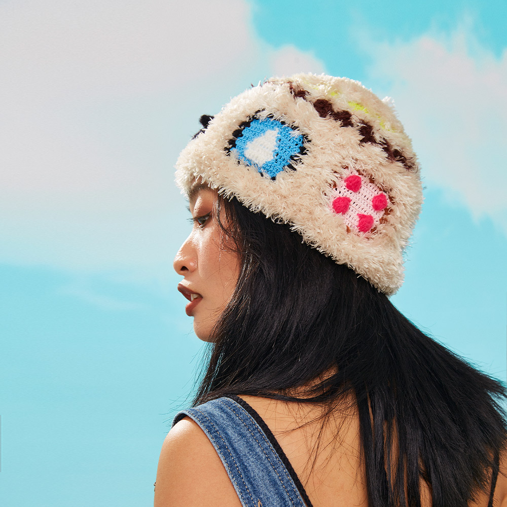 Side profile view of the Warm Cow Velvet Crochet Hat, highlighting the plush beige base with vibrant blue and bright pink block accents.