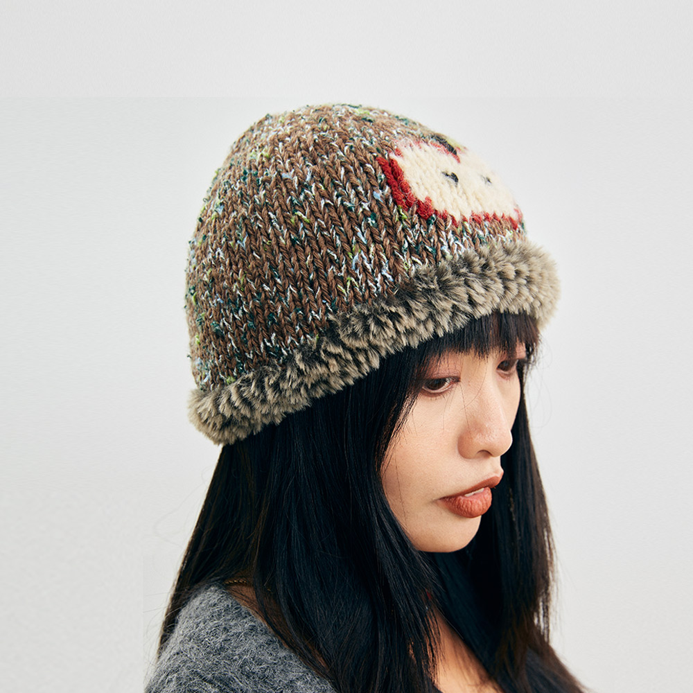 Side profile view of a model wearing the Wool Apple Crochet Hat, highlighting the multi-color speckled tweed yarn structure.