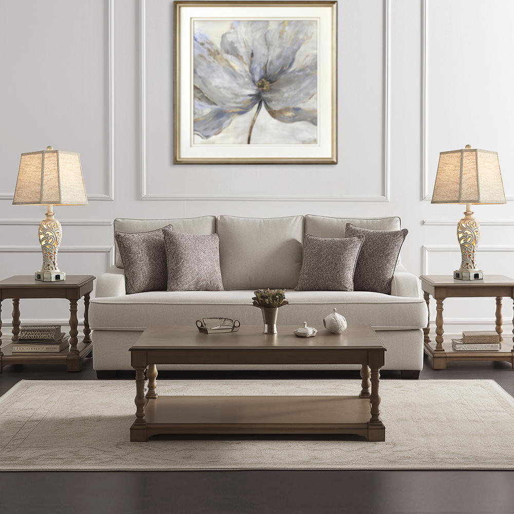 The matching pair of washed white table lamp with carved branch & leaf pattern, they are sitting on the side tables beside a sofa in a living room.