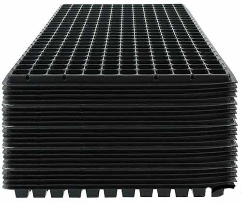 A close up of a stack of tray inserts for starting seeds.