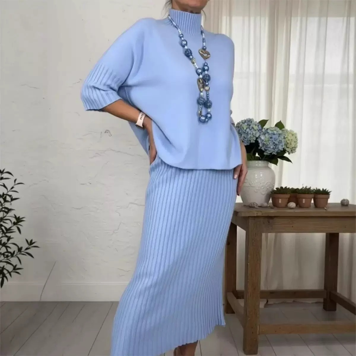 Elegáns, kétrészes szett, amely egy kötött pulóverből és egy midi szoknyából áll