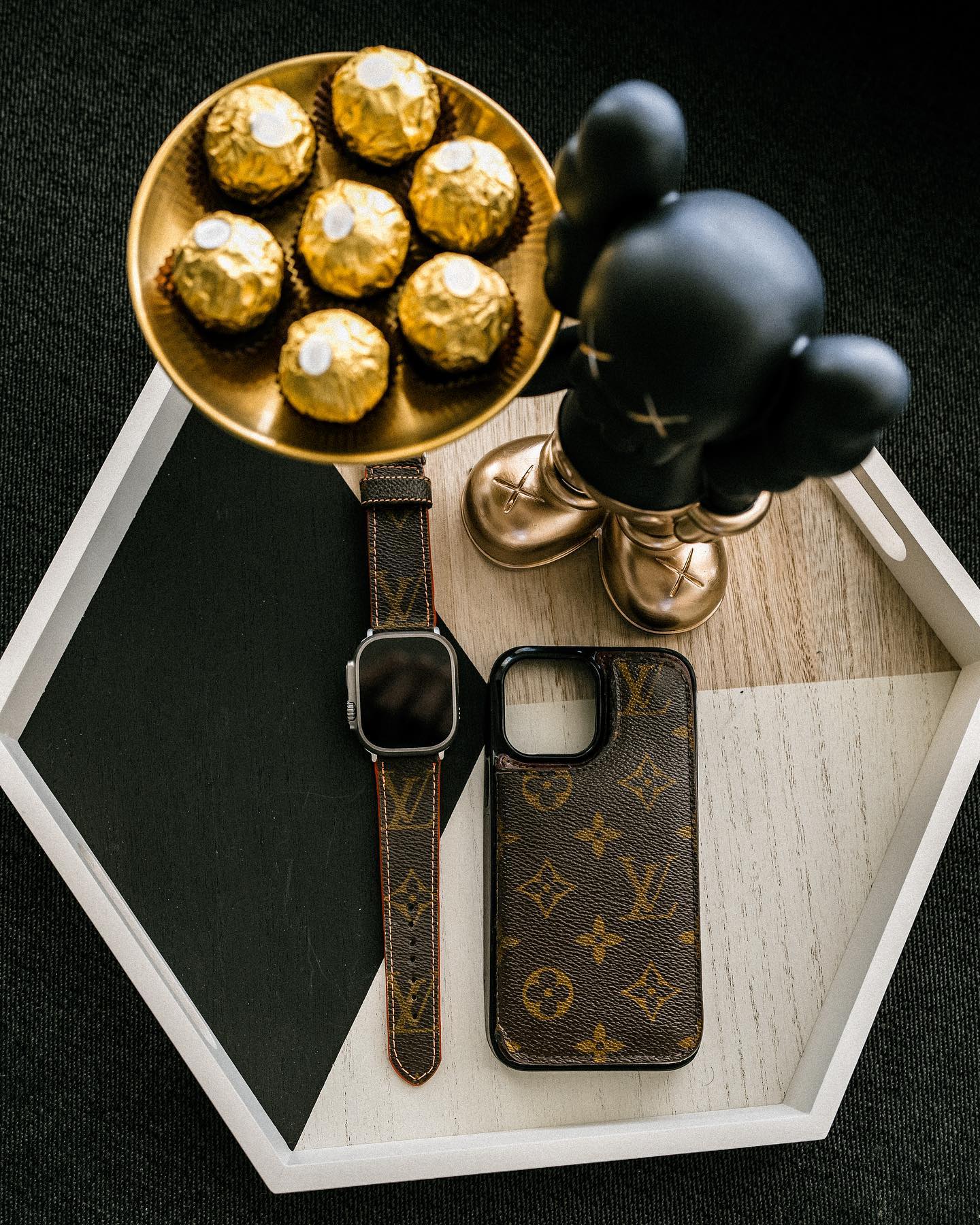 A flat lay showing matching sets of iPhone cases and Apple Watch bands in various luxury styles.