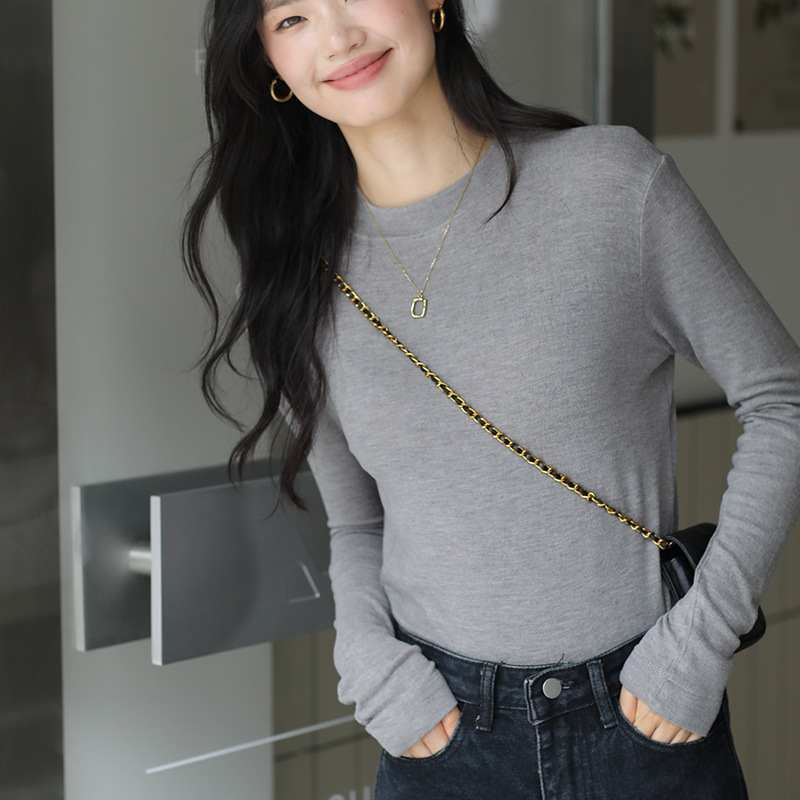 Long sleeved top with high collar on the outside and knitted sweater on the inside