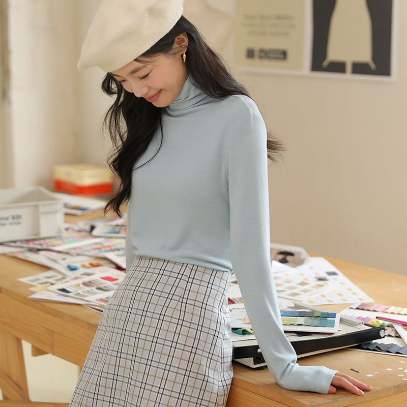Long sleeved top with high collar on the outside and knitted sweater on the inside