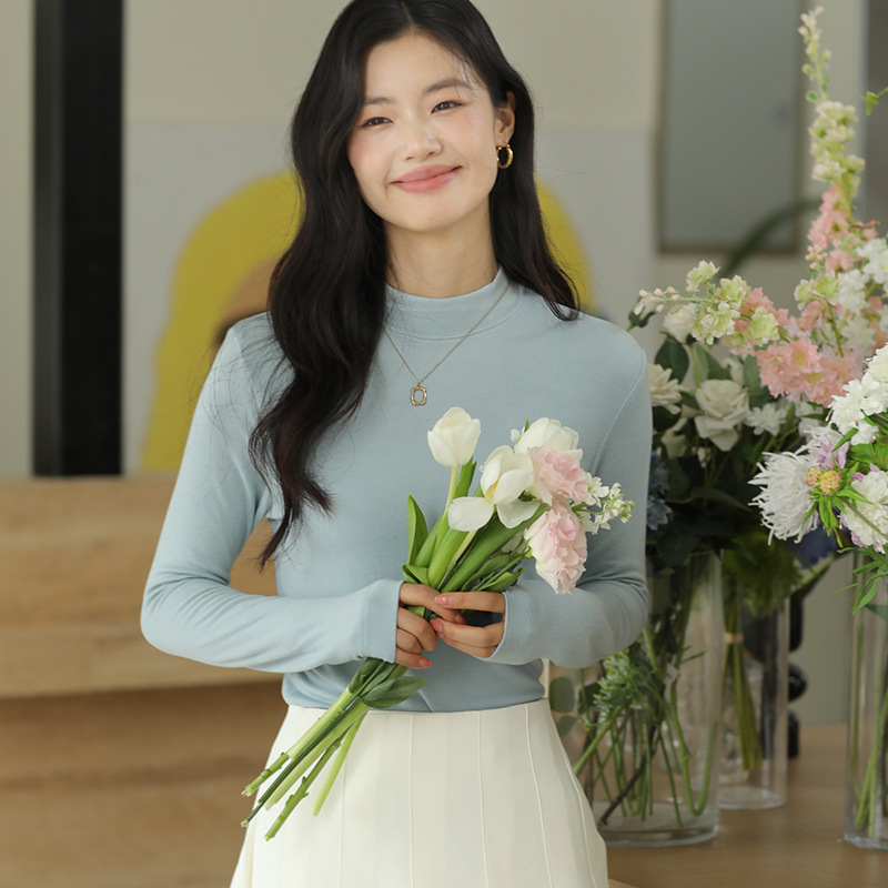 Long sleeved top with high collar on the outside and knitted sweater o