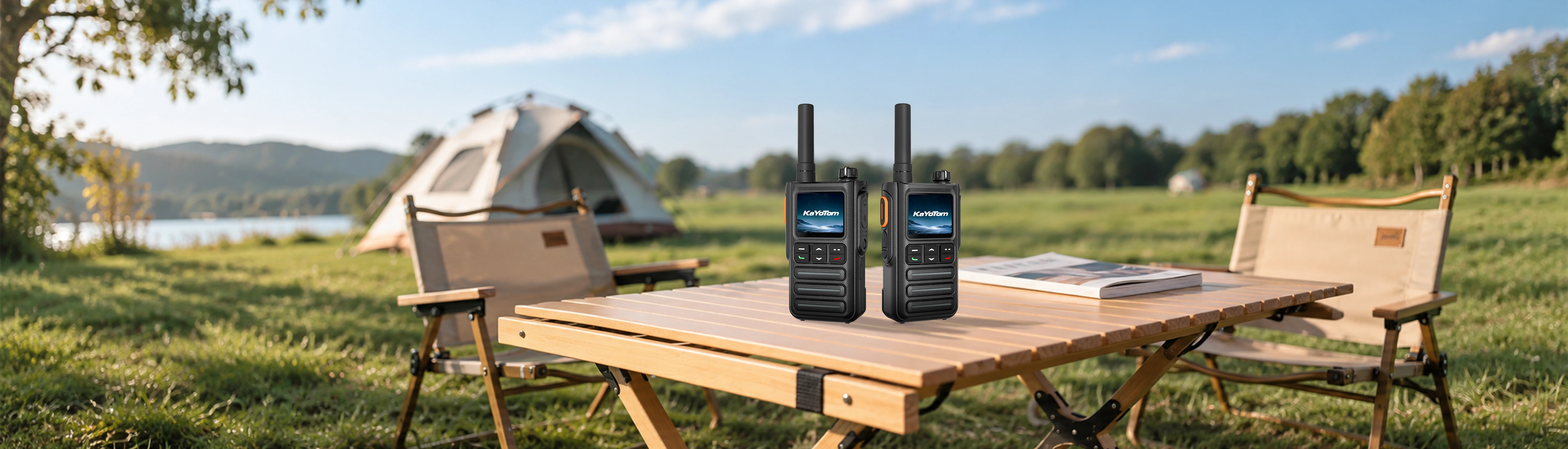 KayoTom G09 rugged dual two-way radios showcased on a wooden camp table with an outdoor nature and tent camping background