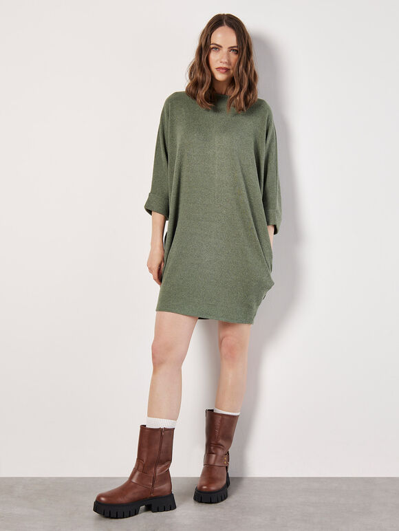 A greenish-brown knitted dress in a cocoon shape with ruffles along the edges