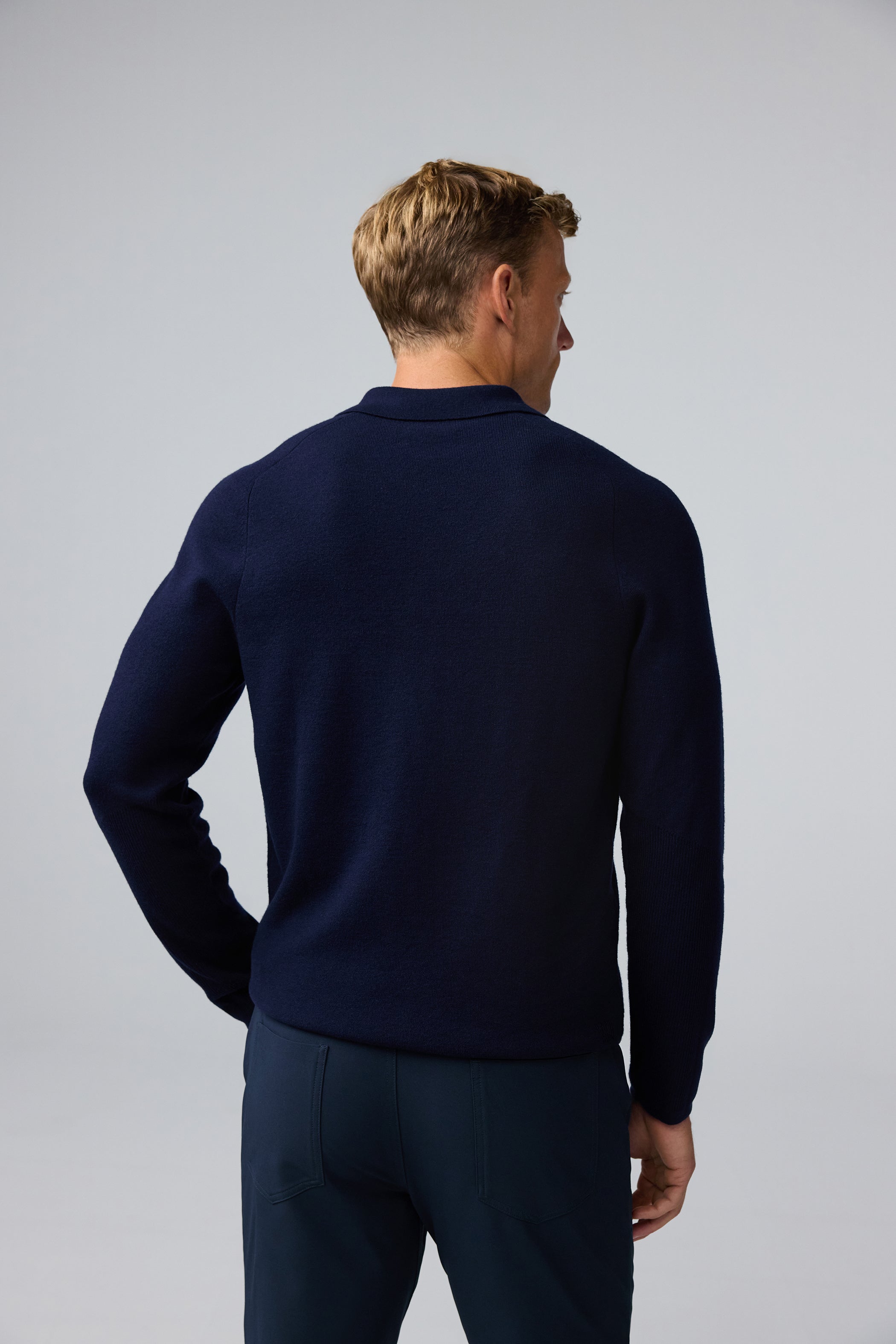 Back view of man wearing Tech Merino Sweater Polo in Total Eclipse