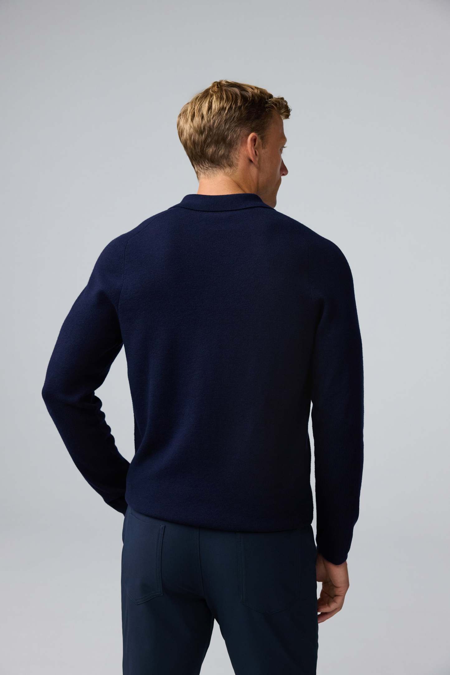 Back view of man wearing Tech Merino Sweater Polo in Total Eclipse