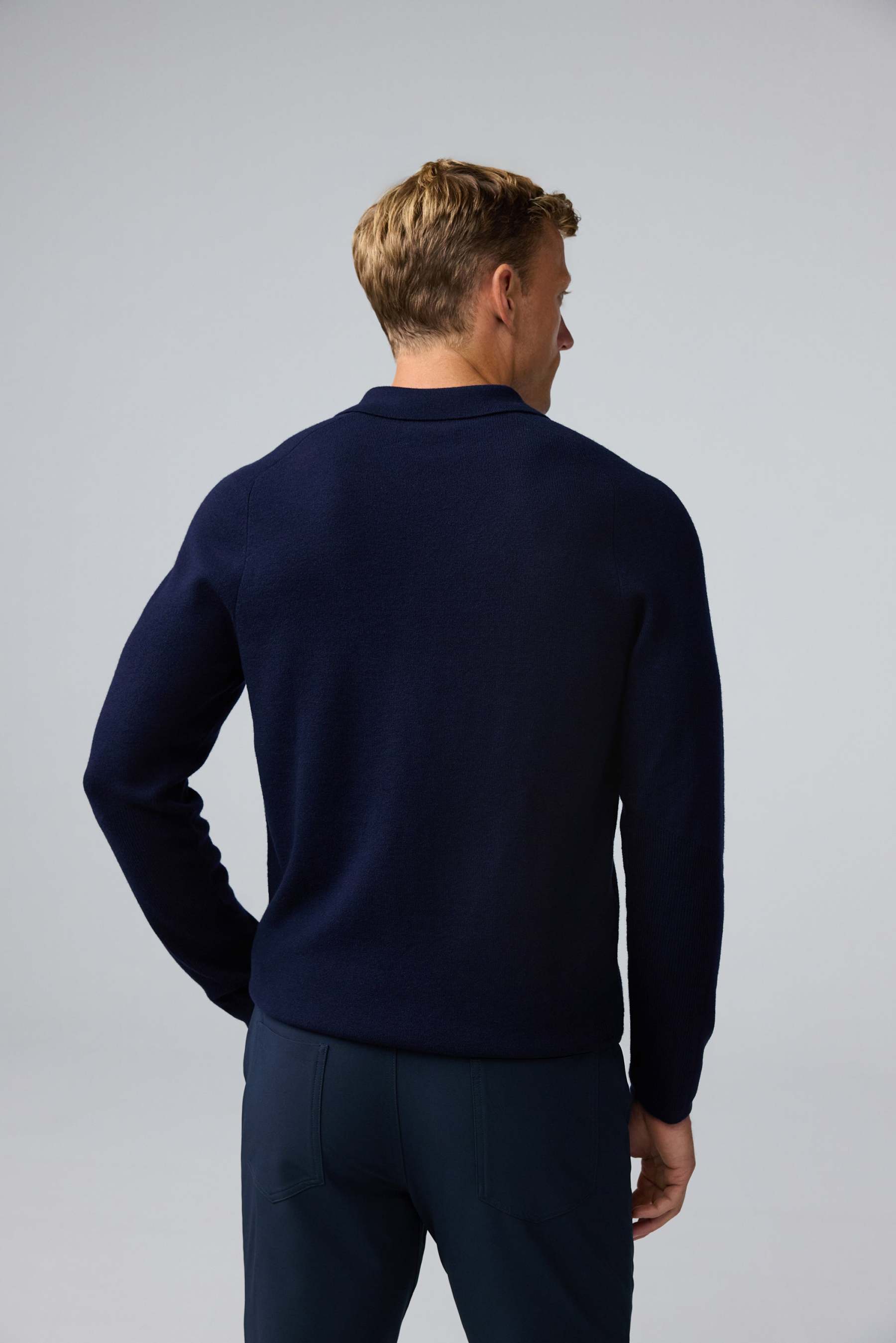 Back view of man wearing Tech Merino Sweater Polo in Total Eclipse