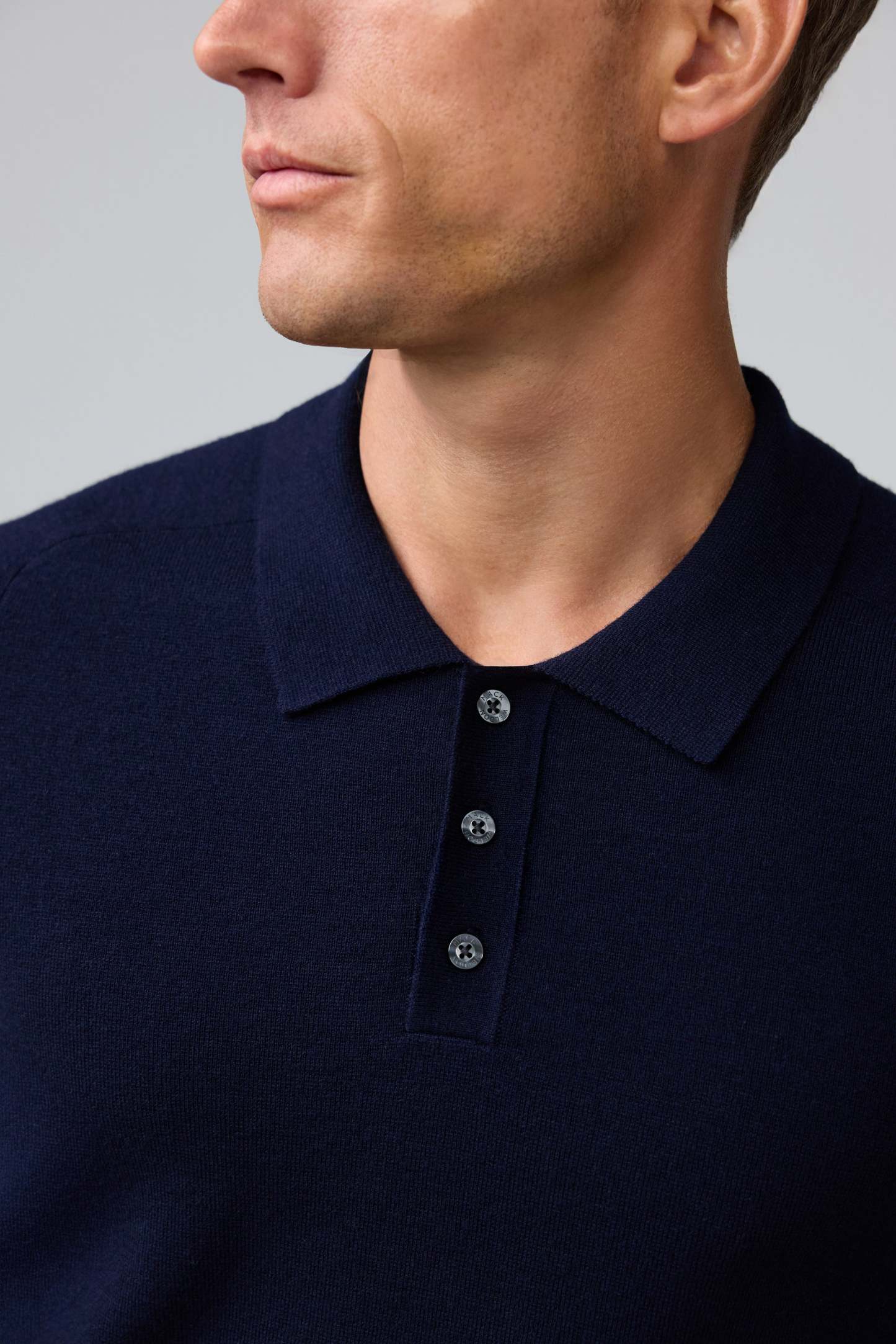 Detail collar view of man wearing Tech Merino Sweater Polo in Total Eclipse