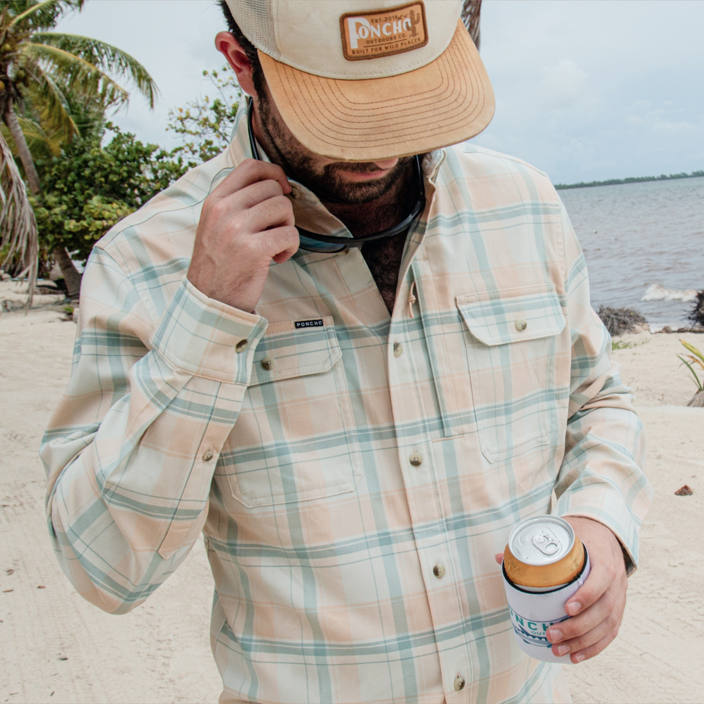 man holding beverage wearing encinitas flannel