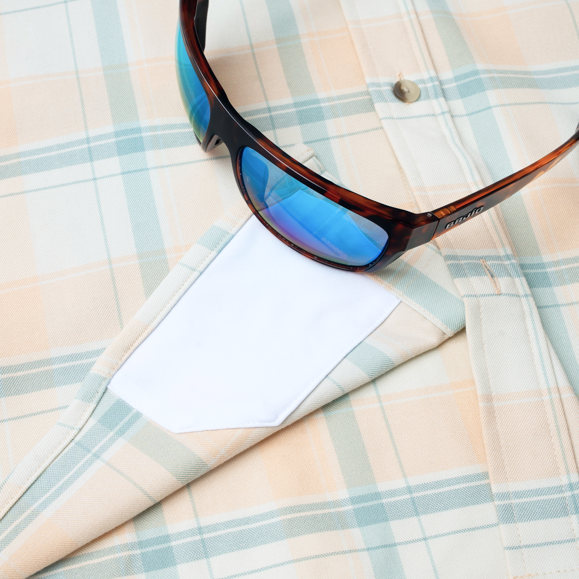 sunglasses with lens cleaner on shirt
