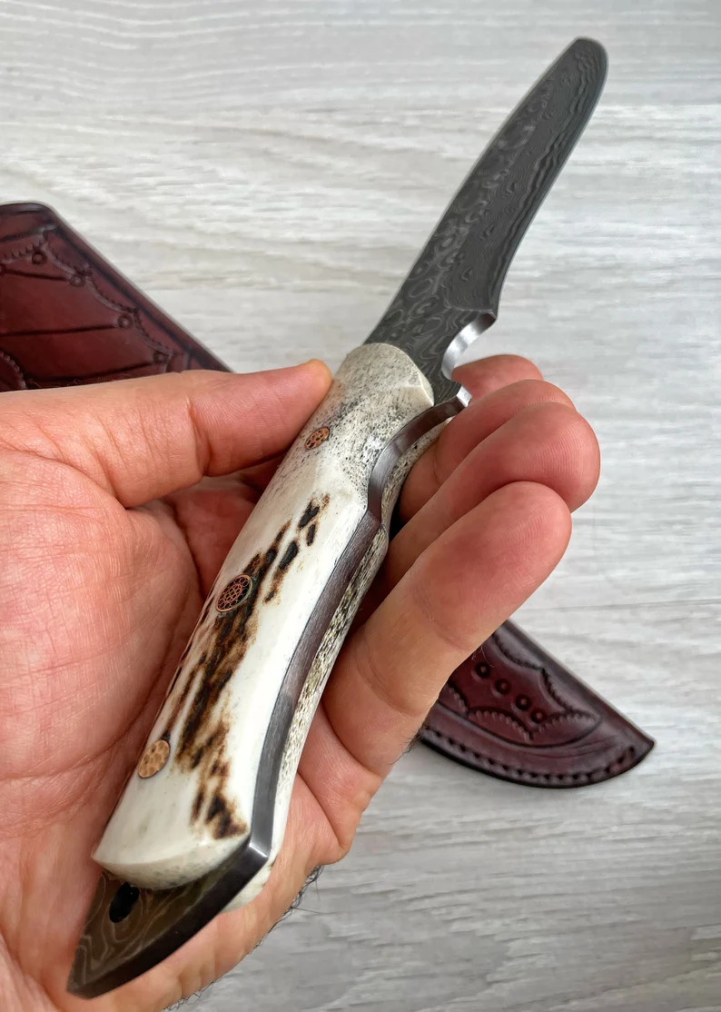 Ένα γνήσιο μαχαίρι Damascus Bowie, με κέρατο ελαφιού και λαβή σφενδάμου, 150 στρώσεις σφυρηλάτησης, χειροποίητο από σιδηρουργό.