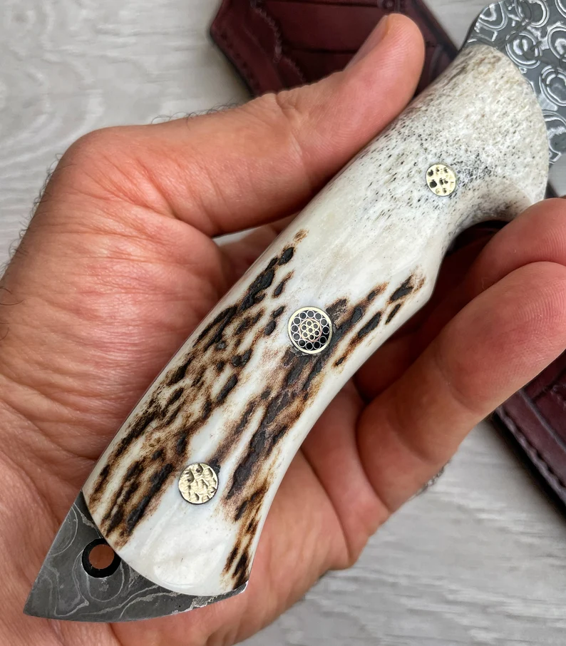 Ένα γνήσιο μαχαίρι Damascus Bowie, με κέρατο ελαφιού και λαβή σφενδάμου, 150 στρώσεις σφυρηλάτησης, χειροποίητο από σιδηρουργό.
