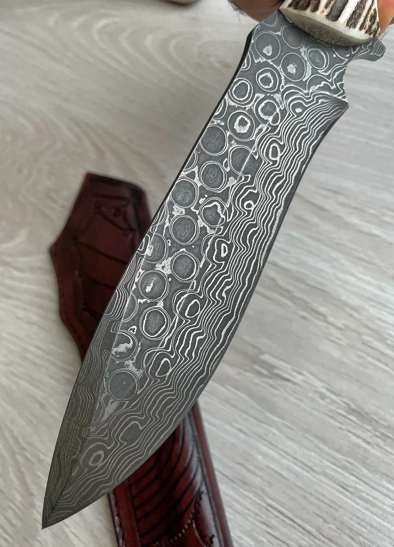 Ένα γνήσιο μαχαίρι Damascus Bowie, με κέρατο ελαφιού και λαβή σφενδάμου, 150 στρώσεις σφυρηλάτησης, χειροποίητο από σιδηρουργό.