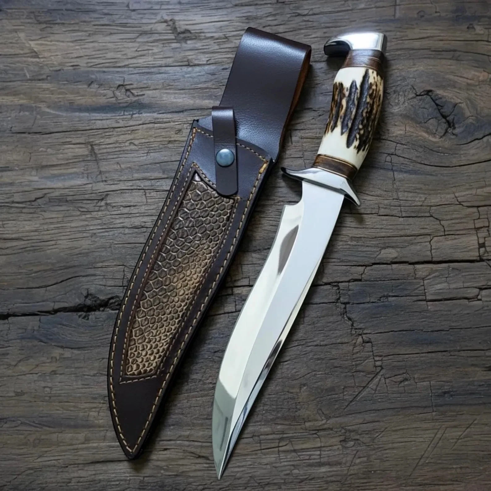 Ručne vyrobený nôž Bowie z vysoko uhlíkovej ocele s jeleňou rukoväťou a koženým puzdrom.