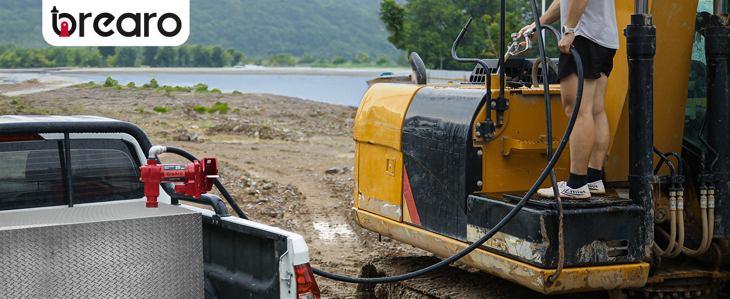 BreAro 20 GPM fuel transfer pump installed on a truck bed, refueling heavy construction equipment at a worksite near a waterbody, showcasing efficient fuel transfer for industrial use.
